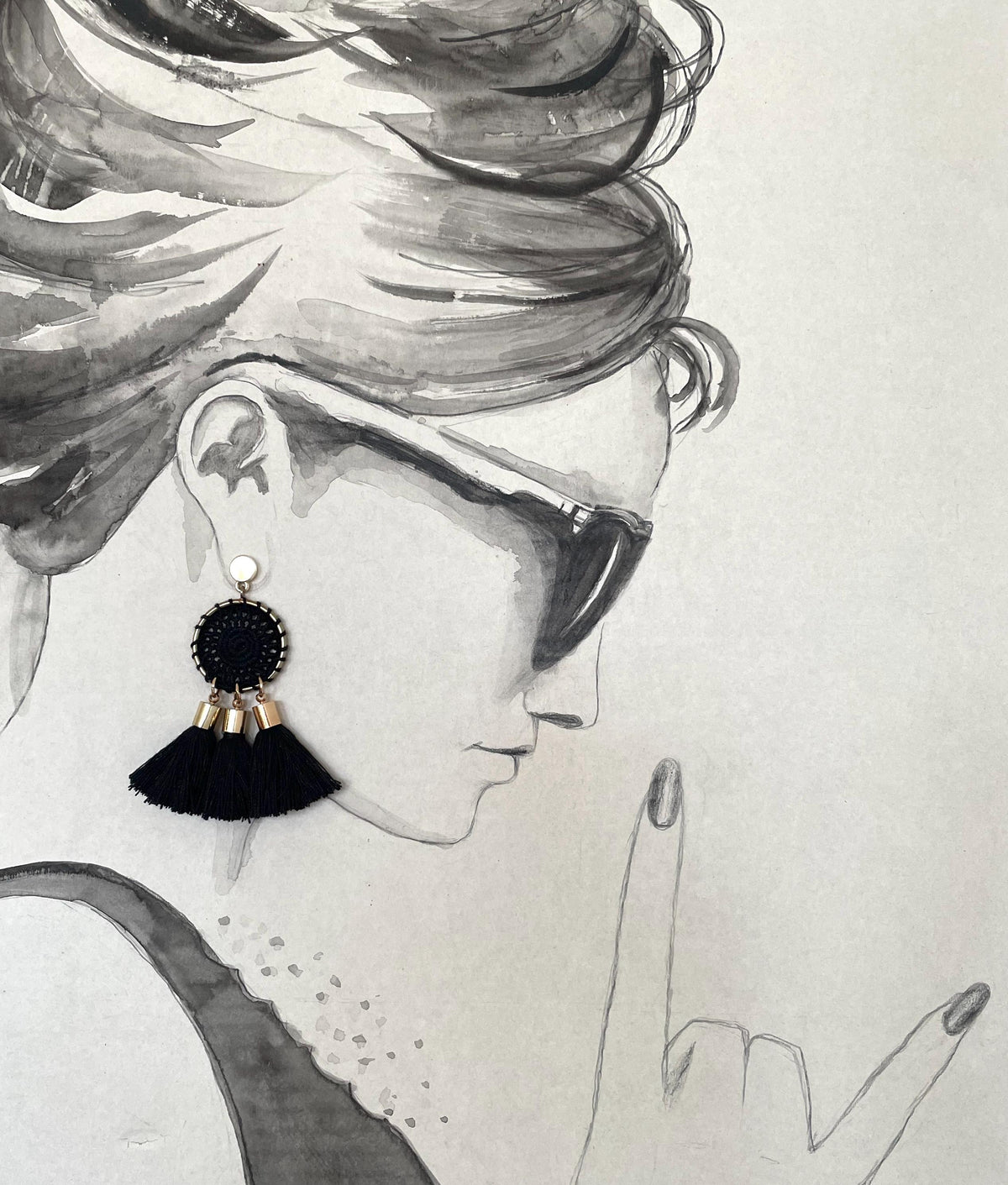A black and white watercolor sketch of a woman in profile wearing a dangling tassel earring and sunglasses, with a hand gesture near her face.