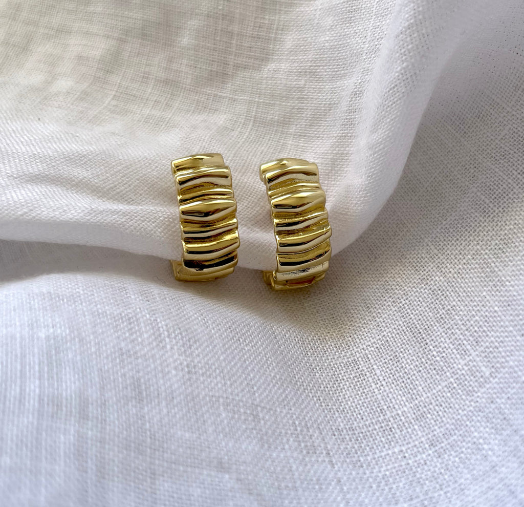 A pair of gold huggie hoop earrings with a crinkled wavy, ridged texture, displayed on a draped white linen fabric background.

waterproof earrings

skin friendly earrings

sea water friendly earrings

round hoops

modern hoops

modern gold hoops

hoops

hoop earrings

golden hoops

gold hoops

gold plated hoops

cute hoops

crinkled hoops

contemporary hoops

circular hoops

brass hoops

brass hoop earrings