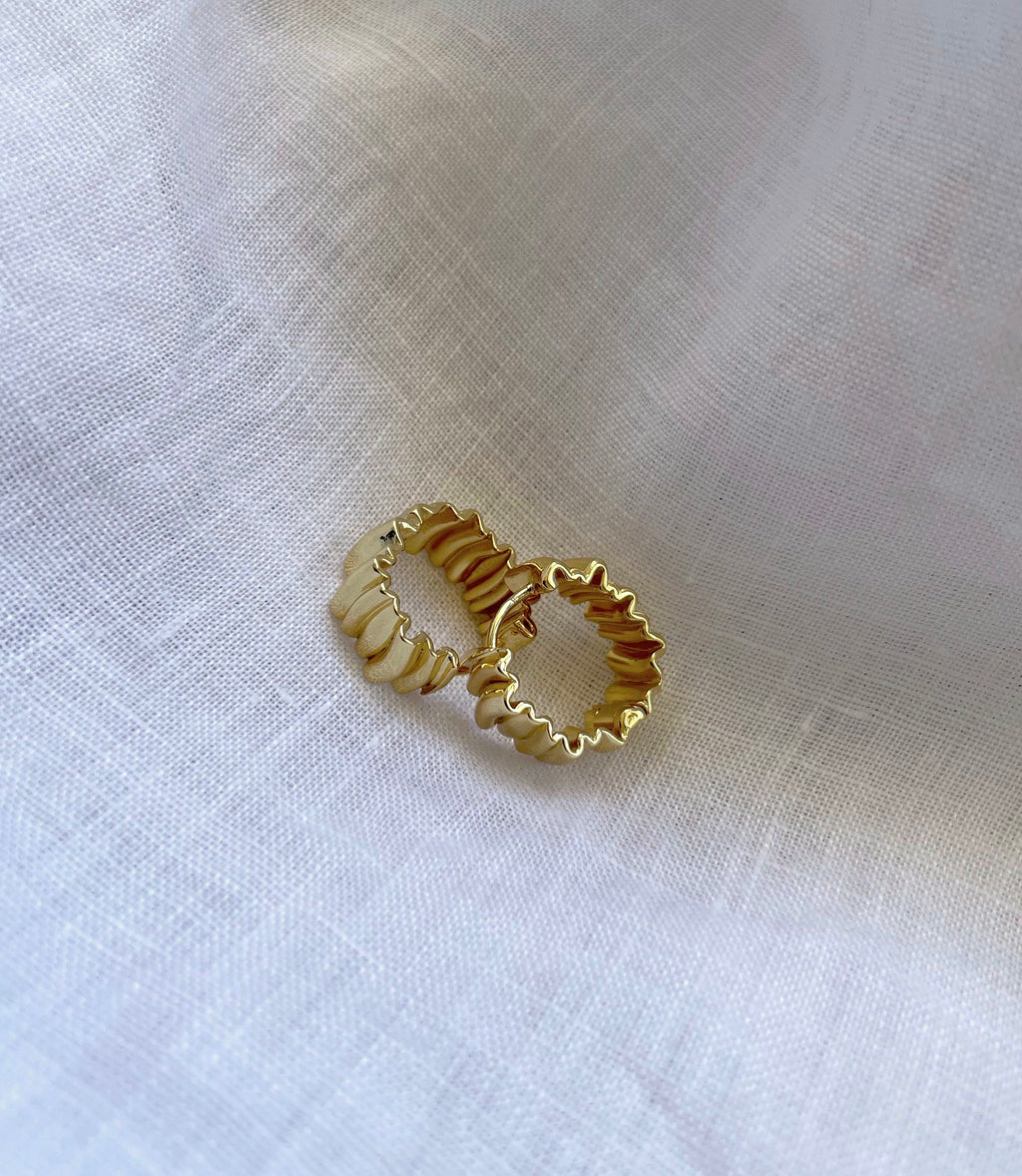 Two gold-toned 18K gold plated textured earrings with a wavy, scalloped edge design, displayed on a soft, white linen fabric background.

waterproof earrings

skin friendly earrings

sea water friendly earrings

round hoops

modern hoops

modern gold hoops

hoops

hoop earrings

golden hoops

gold hoops

gold plated hoops

cute hoops

crinkled hoops

contemporary hoops

circular hoops

brass hoops

brass hoop earrings