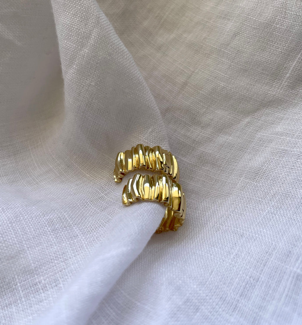 A pair of textured 18K gold plated huggie hoop earrings with a wavy, ridged design, displayed on a piece of draped white linen fabric.


waterproof earrings

skin friendly earrings

sea water friendly earrings

round hoops

modern hoops

modern gold hoops

hoops

hoop earrings

golden hoops

gold hoops

gold plated hoops

cute hoops

crinkled hoops

contemporary hoops

circular hoops

brass hoops

brass hoop earrings