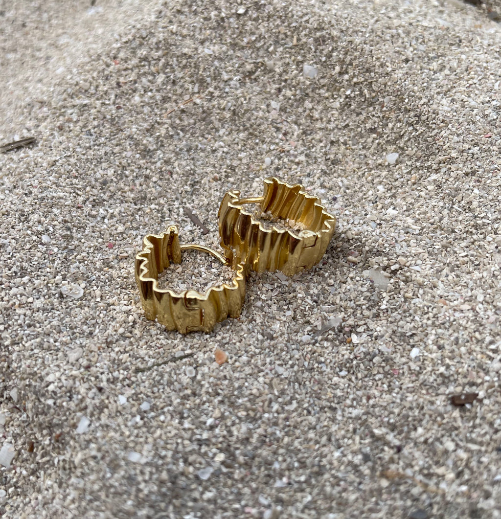 A pair of 18K gold plated gold-toned textured hoop earrings resting on a sandy, gravel-covered surface.

waterproof earrings

skin friendly earrings

sea water friendly earrings

round hoops

modern hoops

modern gold hoops

hoops

hoop earrings

golden hoops

gold hoops

gold plated hoops

cute hoops

crinkled hoops

contemporary hoops

circular hoops

brass hoops

brass hoop earrings