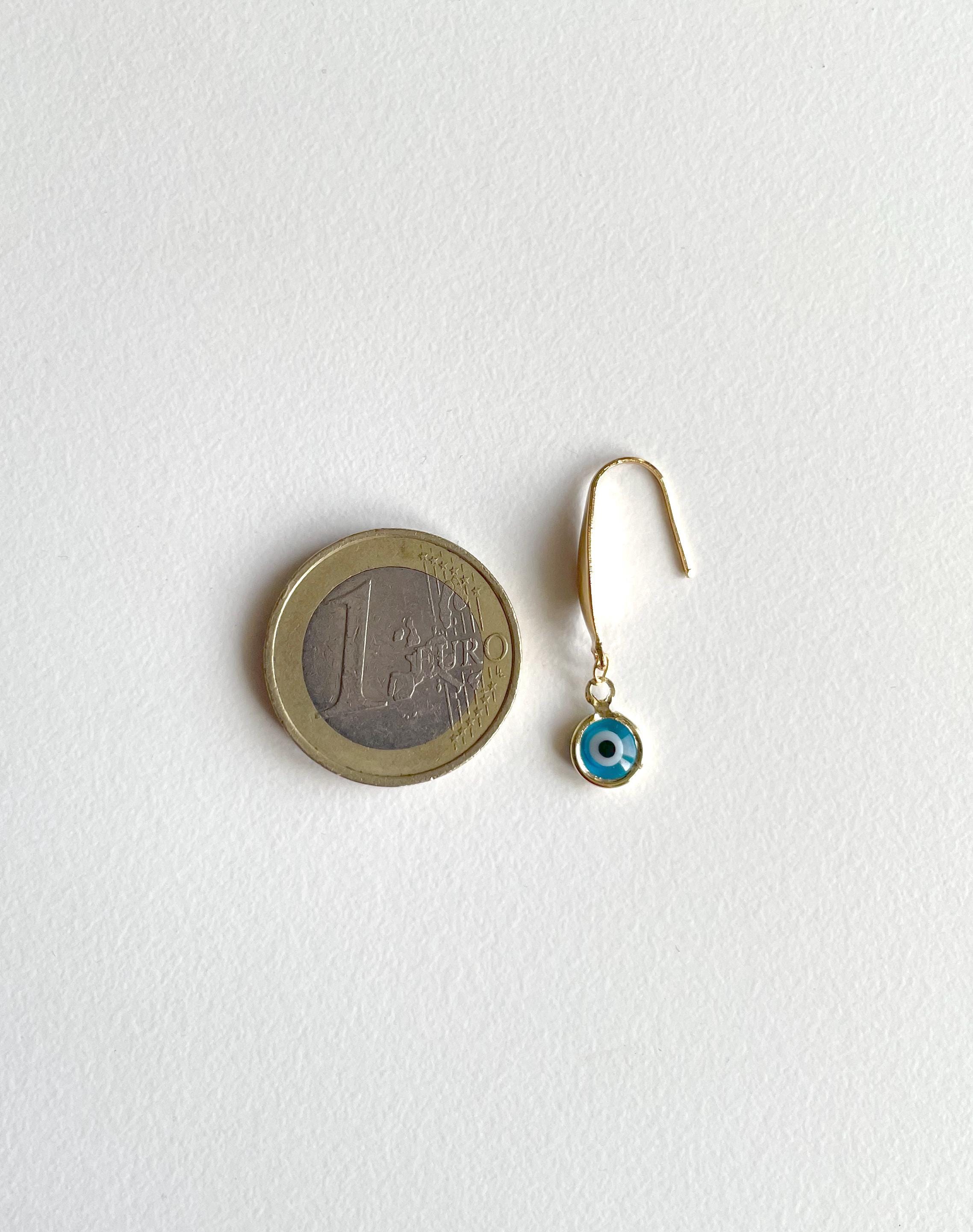 Evil eye earring with golden hook against a 1 euro coin for scale