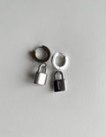 A pair of silver padlock earrings on white background