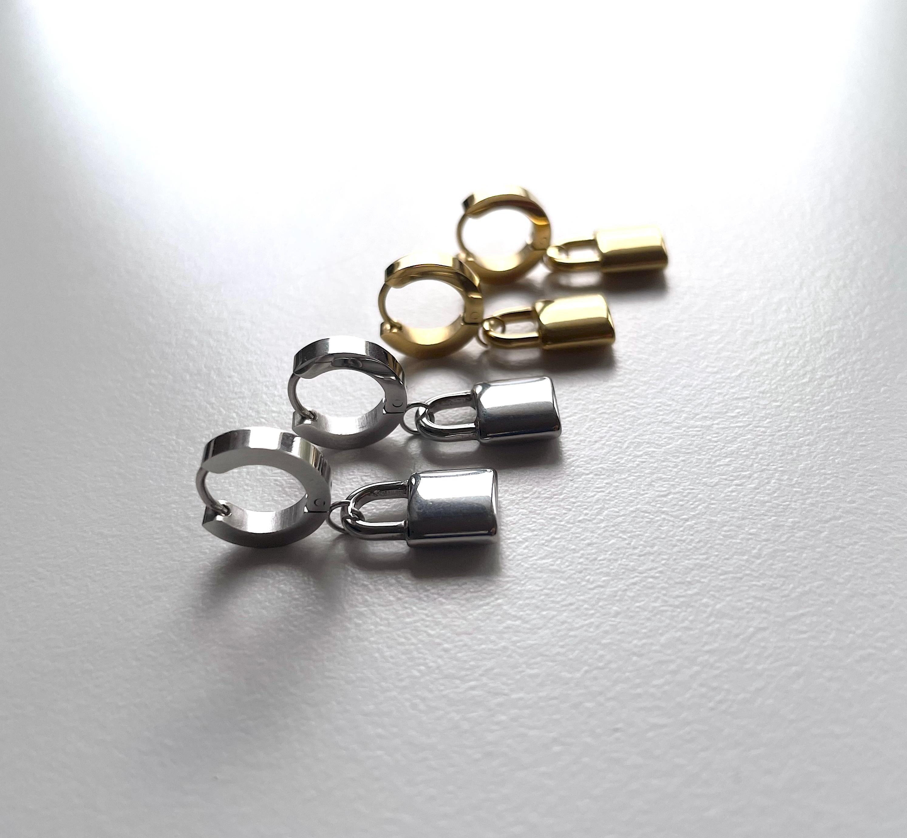 2 pairs of silver and gold padlock earrings against a white background